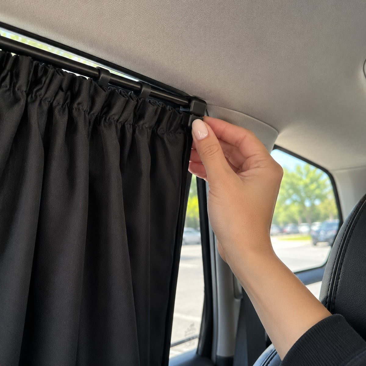 A hand clipping the curtain rail onto the window trim