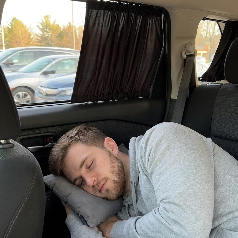 A man napping on the back seat with the car privacy curtains drawn